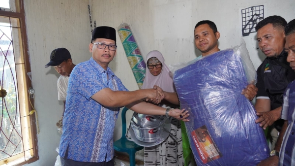 Kadis Sosial Kota Baubau, Hanaruddin saat menyerahkan bantuan kepada korban kebakaran