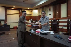 Ketua Badan Pembentukan Perda DPRD Provinsi Sultra, H Bustam saat menyerahkan dokumen raperda kepada Wakil Ketua DPRD Sultra, H Heri Asiku