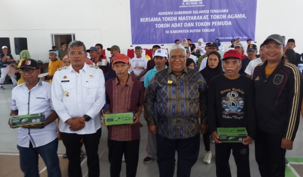 Fajar Ishak dan Pj Bupati Buton Tengah Muhammad Yusuf mendampingi GUbernur Sultra H Ali Mazi Menyerahkan Bantuan Secara Simbolis Kepada Tukang Kayu dan Tukang Batu di Mawasangka Buton tengah